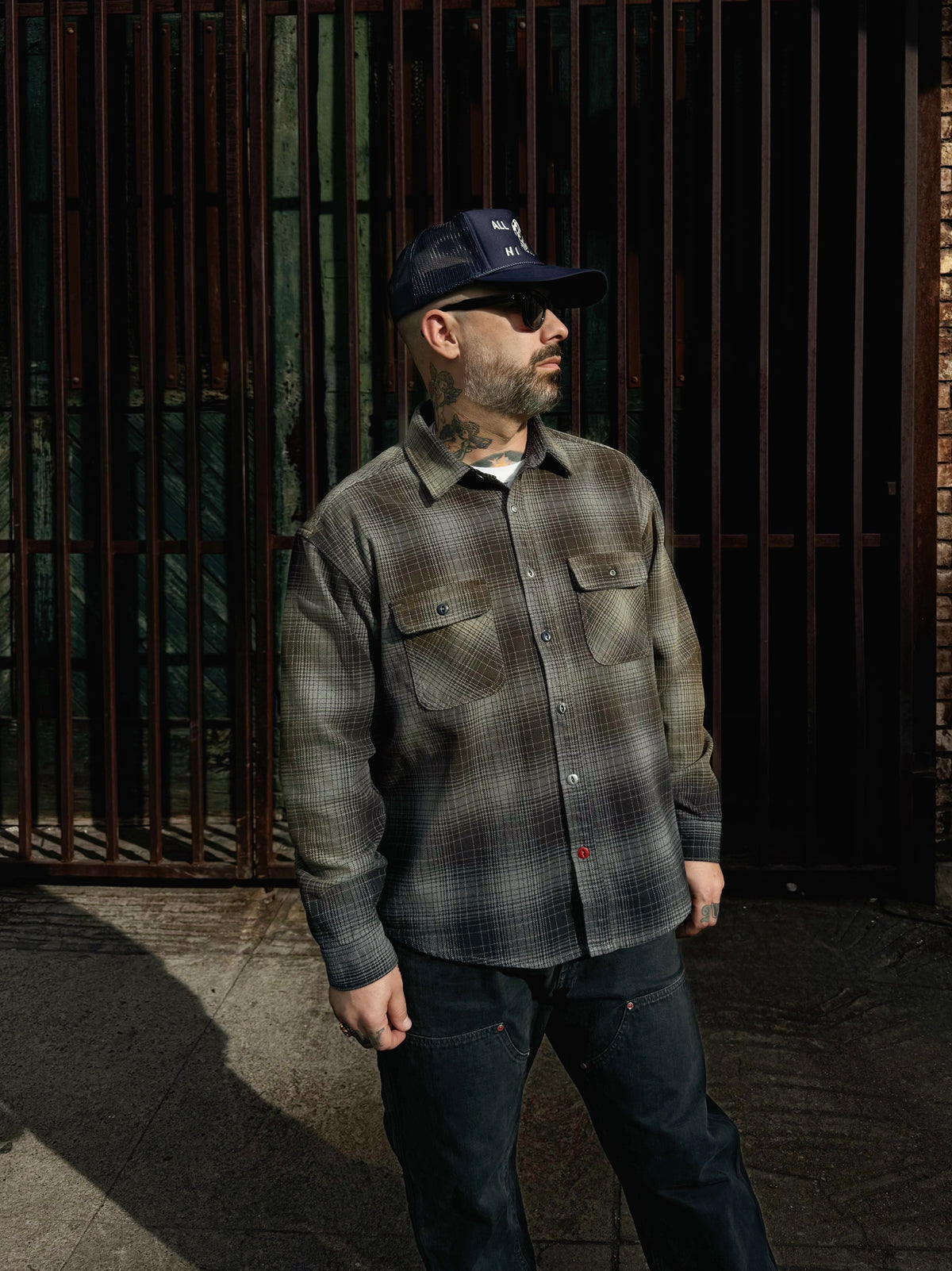 Excel wearing the Baynham Flannel in faded black gray with black ellis double knee jeans facing towards the street in downtown los angeles