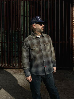  Excel wearing the Baynham Flannel in faded black gray with black ellis double knee jeans facing towards the street in downtown los angeles